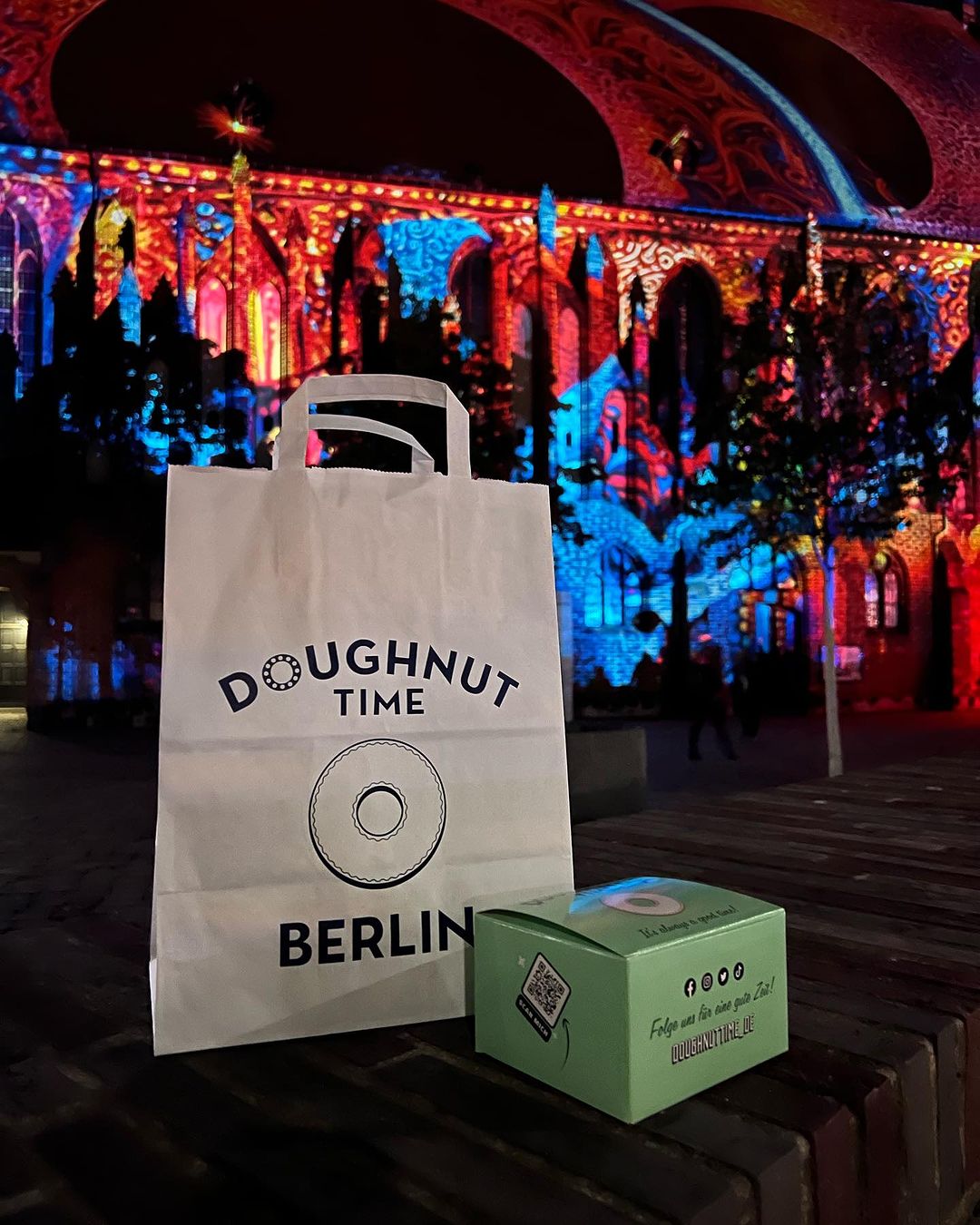 Branded takeaway bag from Doughnut Time Berlin, featuring their logo and showcasing a stylish & eye-catching design for takeaway branding.